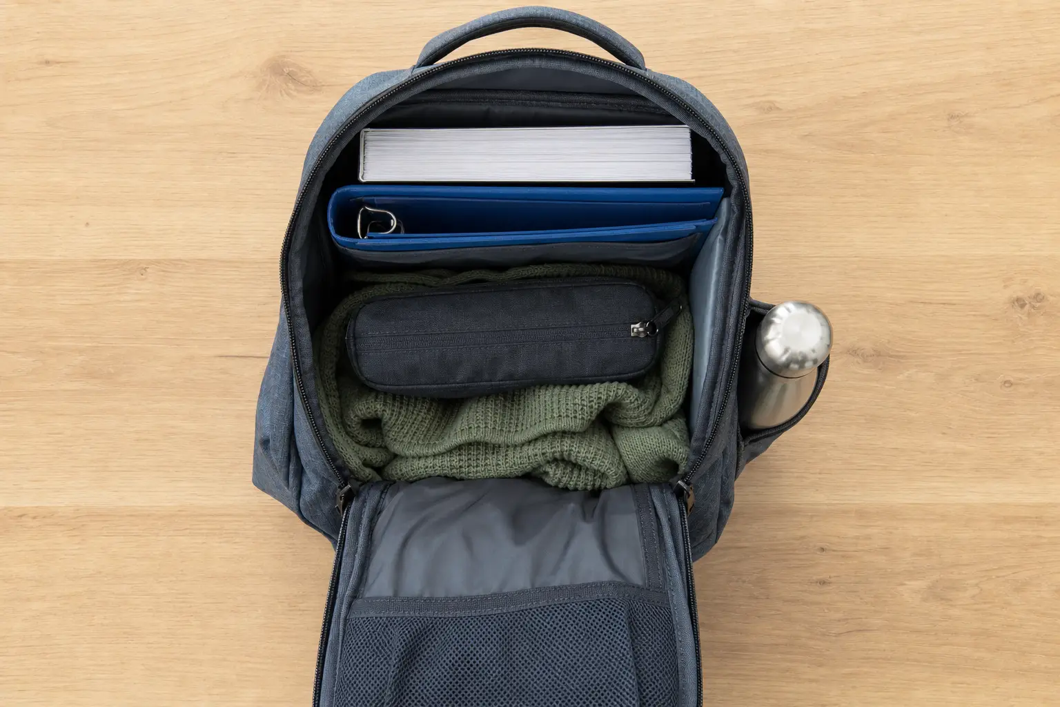 Mochila abierta con libros y botella