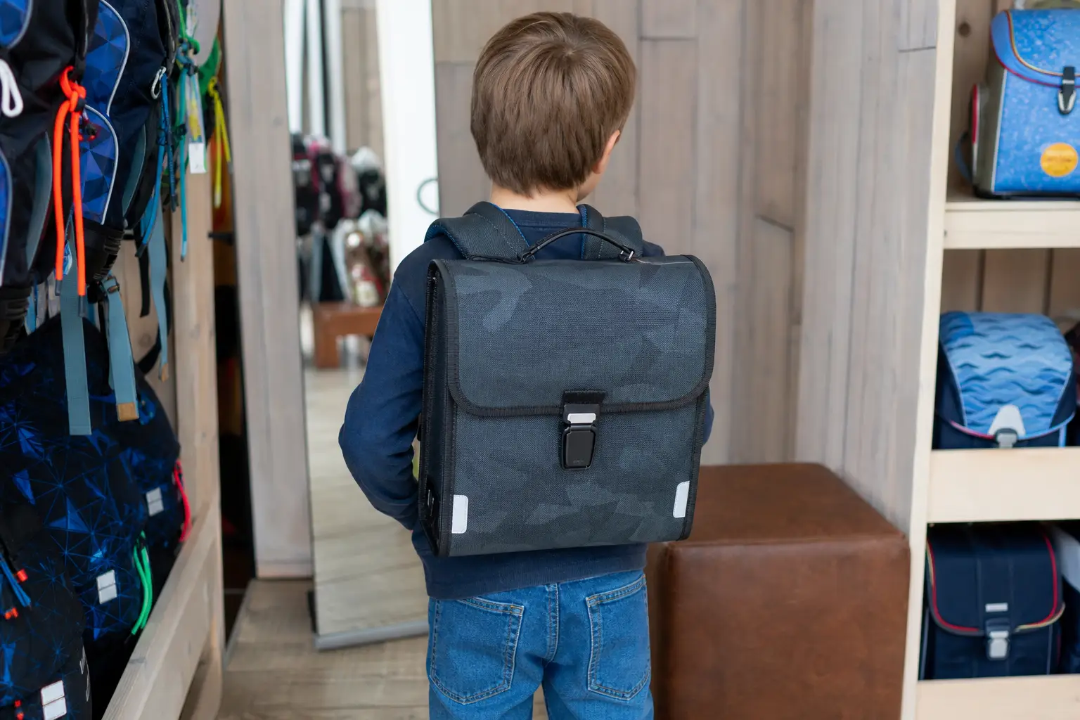Niño llevando una mochila escolar ajustada vista por detrás