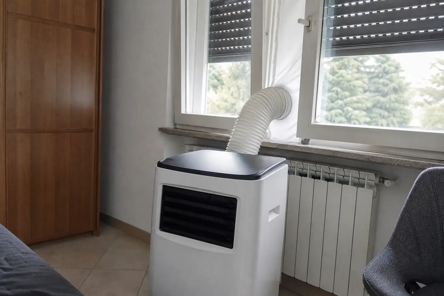 Mobile Klimaanlage mit einem Schlauch, abgedichtet an einem Dreh-Kipp-Fenster