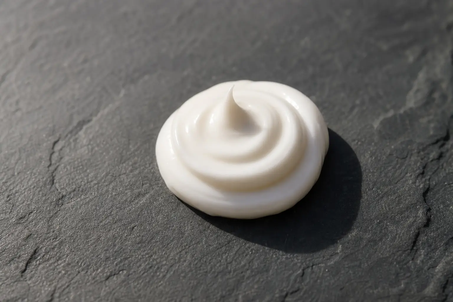 Texture de crème solaire sur une ardoise sombre