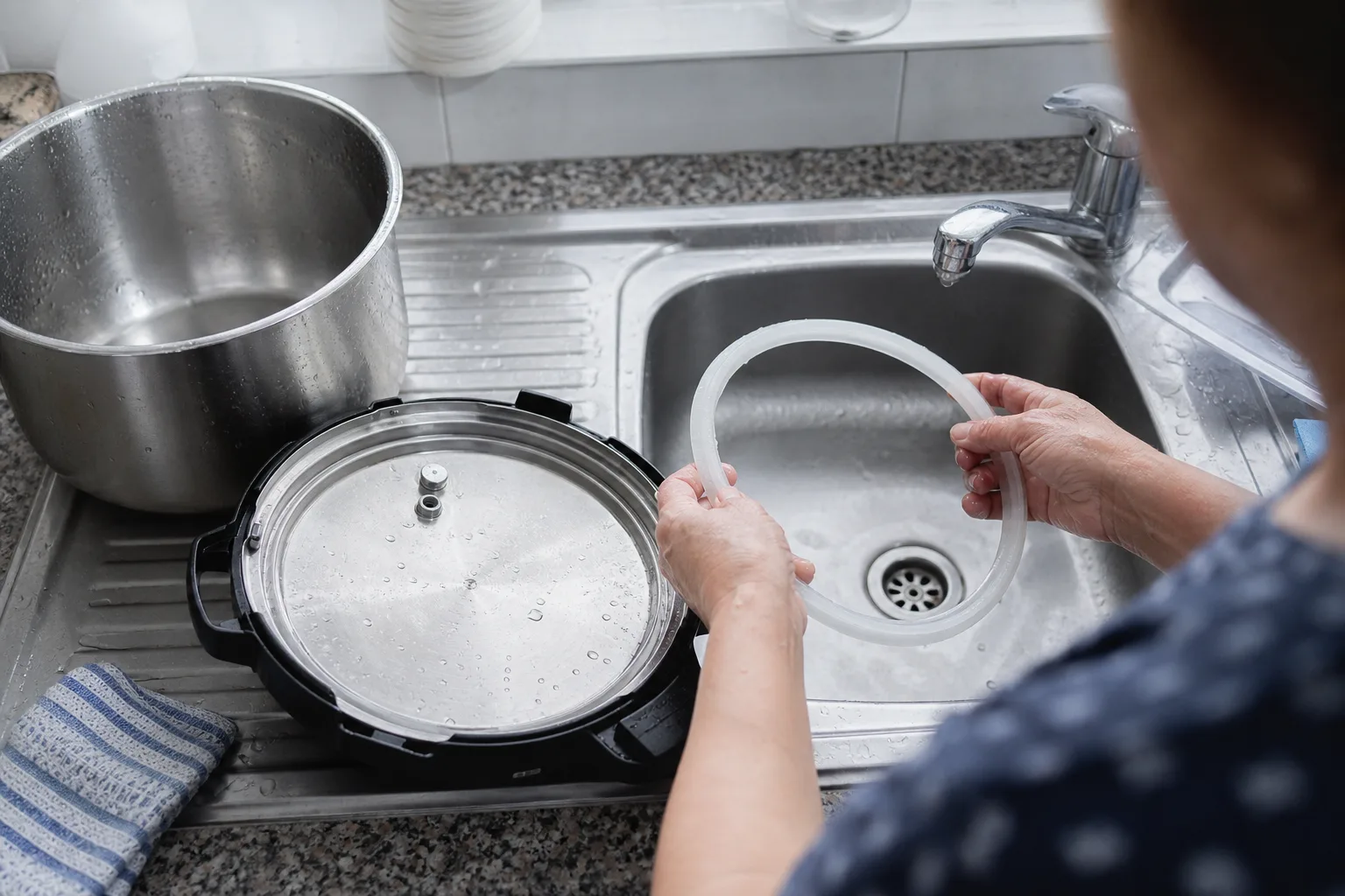 Deckel und Dichtungsring eines elektrischen Schnellkochtopfs bei der Reinigung